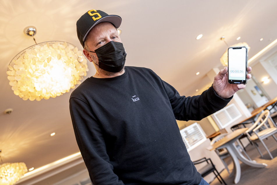Rapper Smudo demonstriert auf seinem Smartphone die funktionsweise der App "Luca".