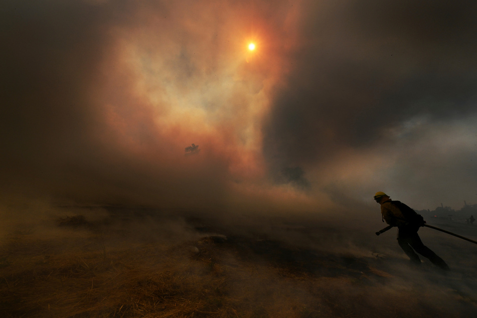 Feuerwehrleute bekämpfen ein Buschfeuer in Kalifornien. In dem Bundesstaat wird es immer heißer und trockener. Dürren und Waldbrände nehmen zu.