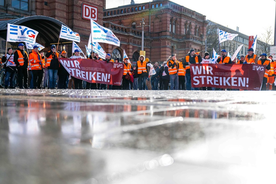 Demonstranten der Eisenbahn- und Verkehrsgewerkschaft (EVG) stehen mit Plakaten vor dem Hauptbahnhof in Bremen.