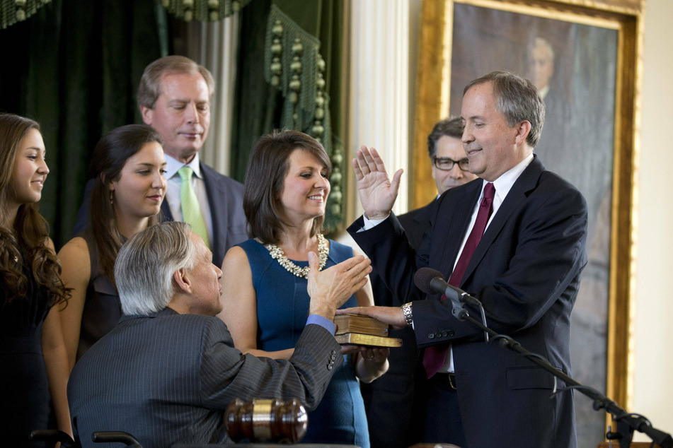 Texas Governor Greg Abbott congratulates Ken Paxton at his swearing in ceremony as the state's new attorney general for Texas on January 5, 2015.