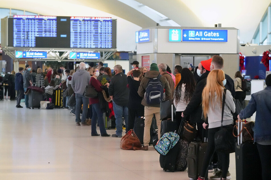 Passengers waited in line for alternative flights at St. Louis-Lambert International Airport in St. Louis on Sunday. United and Delta have blamed coronavirus for staffing problems that led to cancellations.