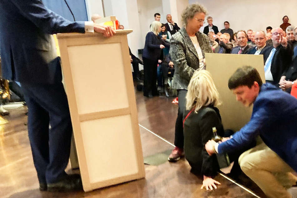 Eine Aktivistin der "Letzten Generation" hatte sich mit der rechten Hand vor dem Rednerpult festgeklebt, doch Vertreter der CDU konnten auch sie vom Boden lösen und aus dem Saal bringen.