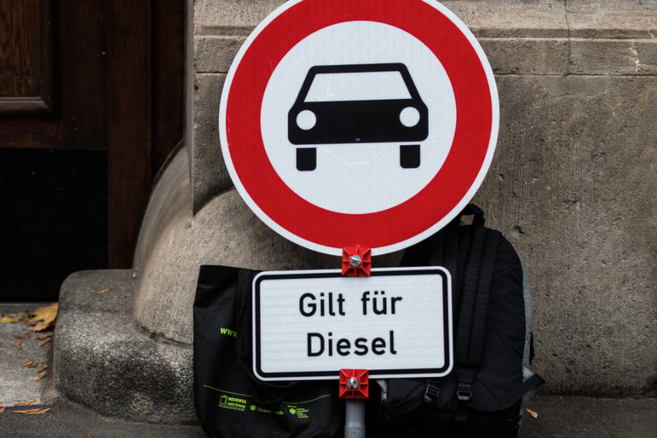 Ein Verkehrsschild "Verbot für Kraftfahrzeuge" mit dem Zusatz "Gilt für Diesel" steht vor einem Gericht.