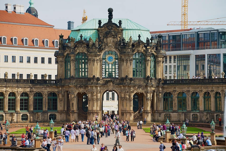 Einwohner und Touristen besuchen den Dresdner Zwinger.