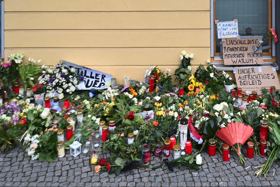 Blumen, Kerzen und Plakate liegen vor dem Eingang zum Wohnheim des diakonischen Anbieters Oberlinhaus. Am Donnerstag gedenken die Stadt Potsdam und die Einrichtung mit einem Gottesdienst der Opfer der Gewalttat vom vergangenen Mittwoch.