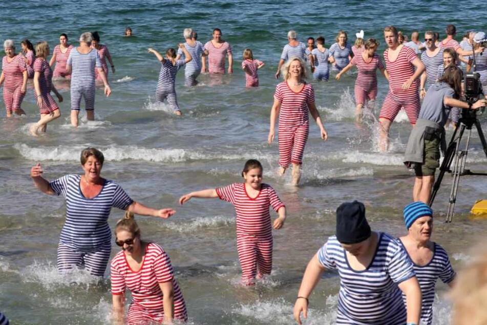 Beim Anbaden gehen die Teilnehmer in rot-weiß und blau-weiß geringelten Badekostümen in die sieben Grad kalte Ostsee.