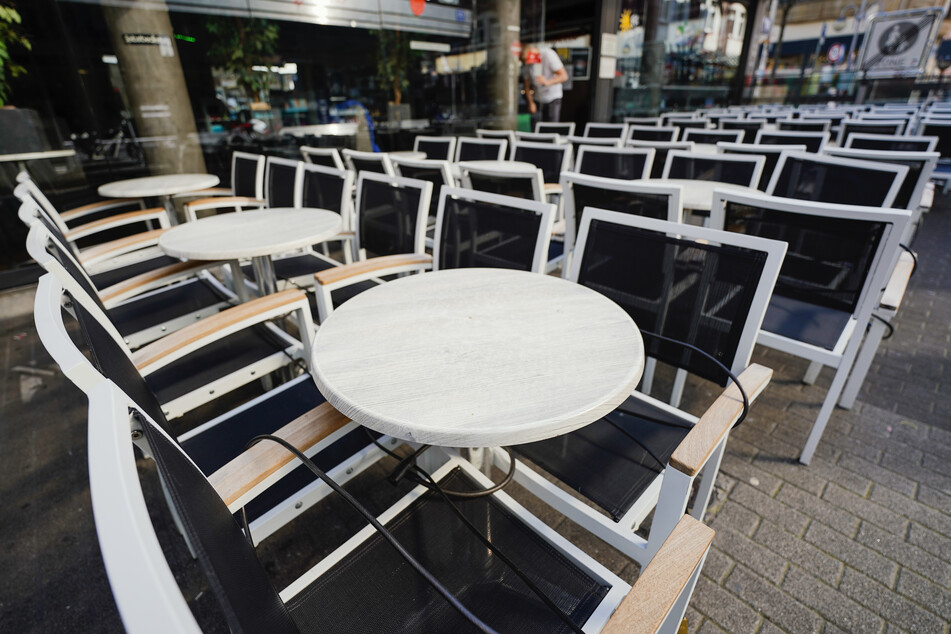 Leere Tische stehen vor einem Restaurant in Mannheim.