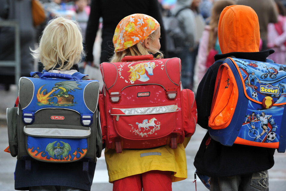 Drei Kinder auf dem Weg zur Schule. Trotz rasant steigender Corona-Zahlen unter Schulkindern plant die Landesregierung keine schärferen Schutzmaßnahmen.