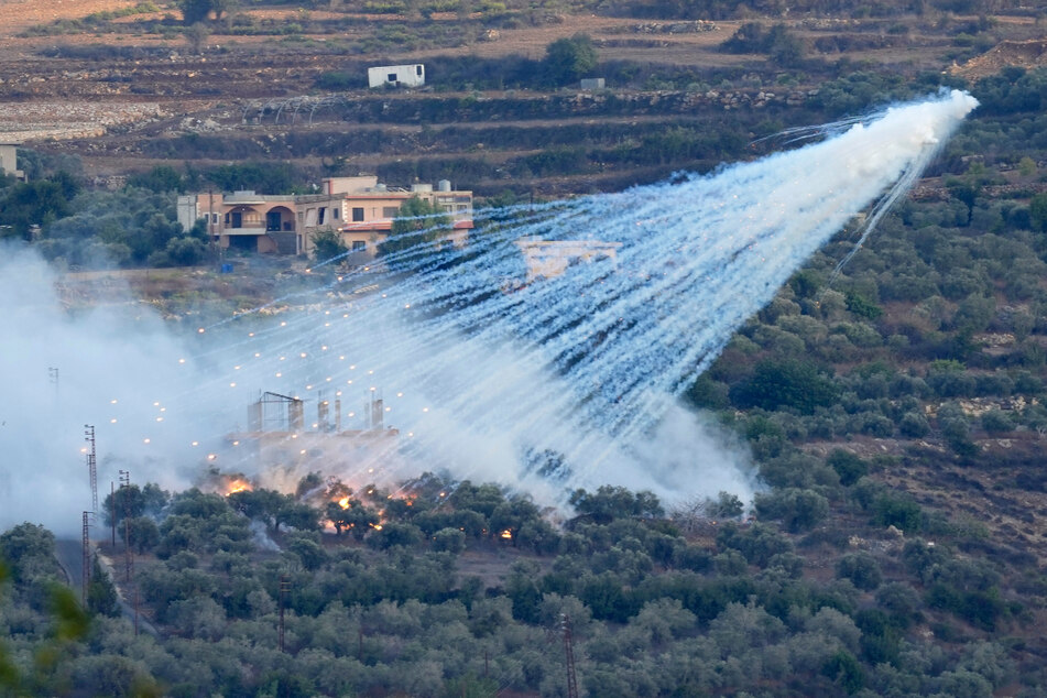 Eine Granate der israelischen Artillerie explodiert über einem Haus im libanesischen Grenzdorf Al-Bustan.