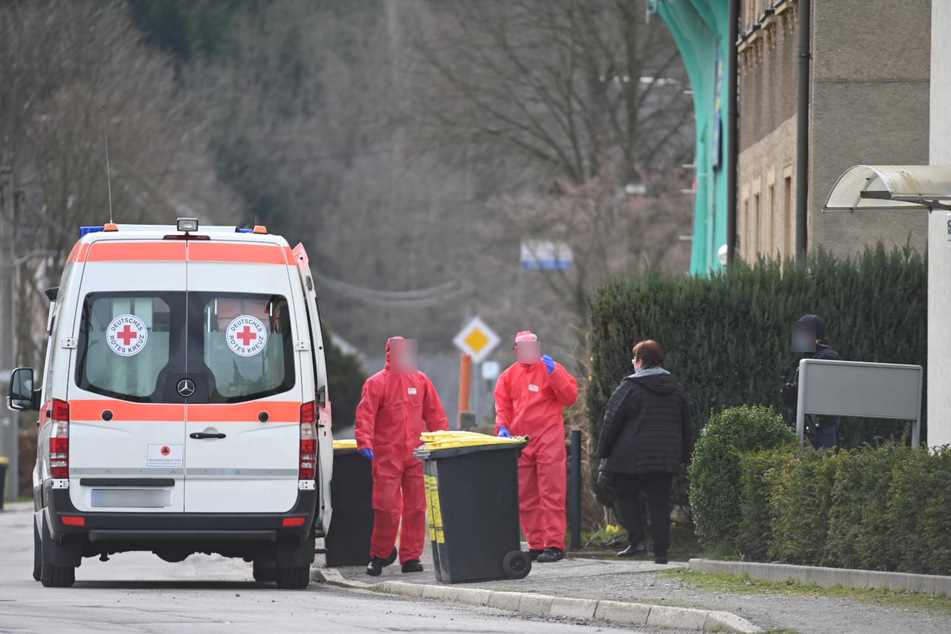 Mitarbeiter vom Deutschen Roten Kreuz holen betroffene Bewohner ab.