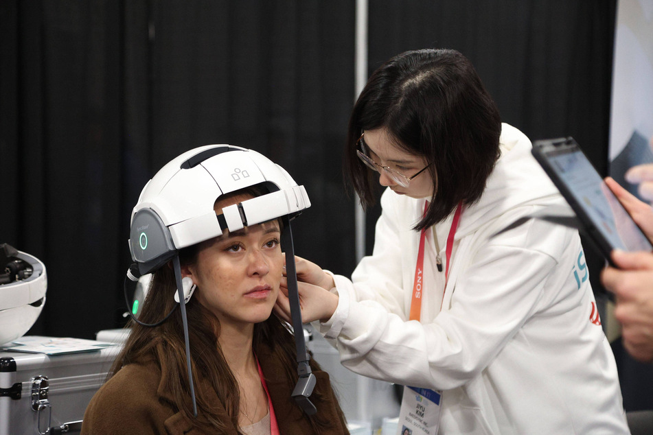 An attendee is fitted with the iMediSync integrated AI mental care device.