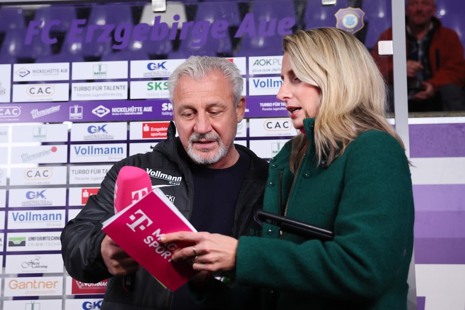 Pavel Dotchev (l.) mit MagentaTV-Moderatorin Stefanie Blochwitz (34). Auf dem Stichwortzettel möchte der FCE-Trainer am Samstag nach dem Spiel nur positive Sätze lesen.