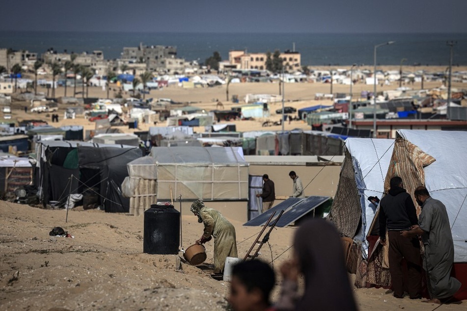 Displaced Palestinians gather at a makeshift camp on the Egyptian border, west of Rafah, in the southern Gaza Strip on January 14, 2024.