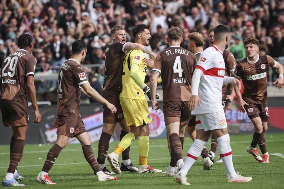 Die Mitspieler feiern Torwart Nikola Vasilj nach seinem gehaltenen Elfmeter.