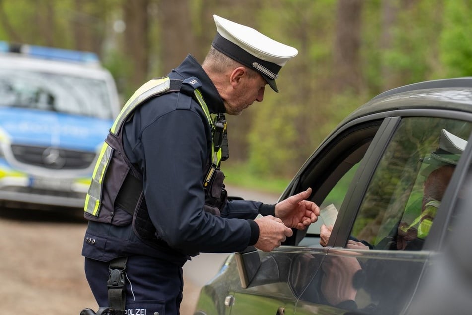 Ein Polizist kontrolliert in Soest im Rahmen der sogenannten "Speedweek" den Fahrzeugschein eines Autofahrers.