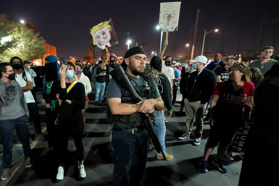Supporters and opponents of President Trump gather in front of a Maricopa County election center.