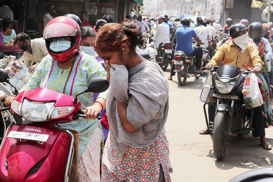 Menschen tragen in Hyderabad Mundschutz als Vorsichtsmaßnahme gegen COVID-19 und ziehen über die Straßen.
