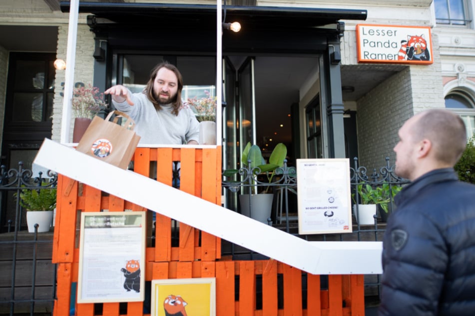 Inhaber Florian Ridder (l) demonstriert mit seinem Geschäftspartner Vincent Domeier, eine neue "Ramen-Rutsche" vor dem Laden.