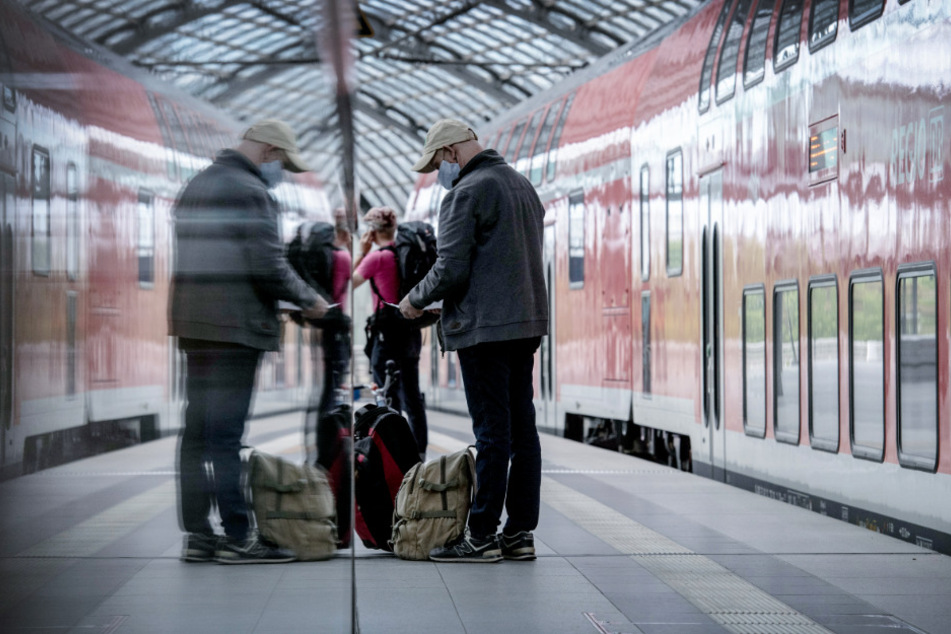 Berlin: Reisende stehen im Hauptbahnhof an einem Zug.