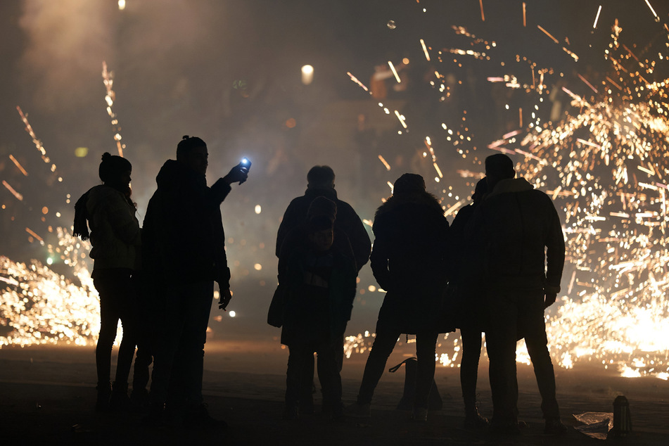 Eine Gruppe junger Menschen entzündet Feuerwerksraketen. (Symbolbild)