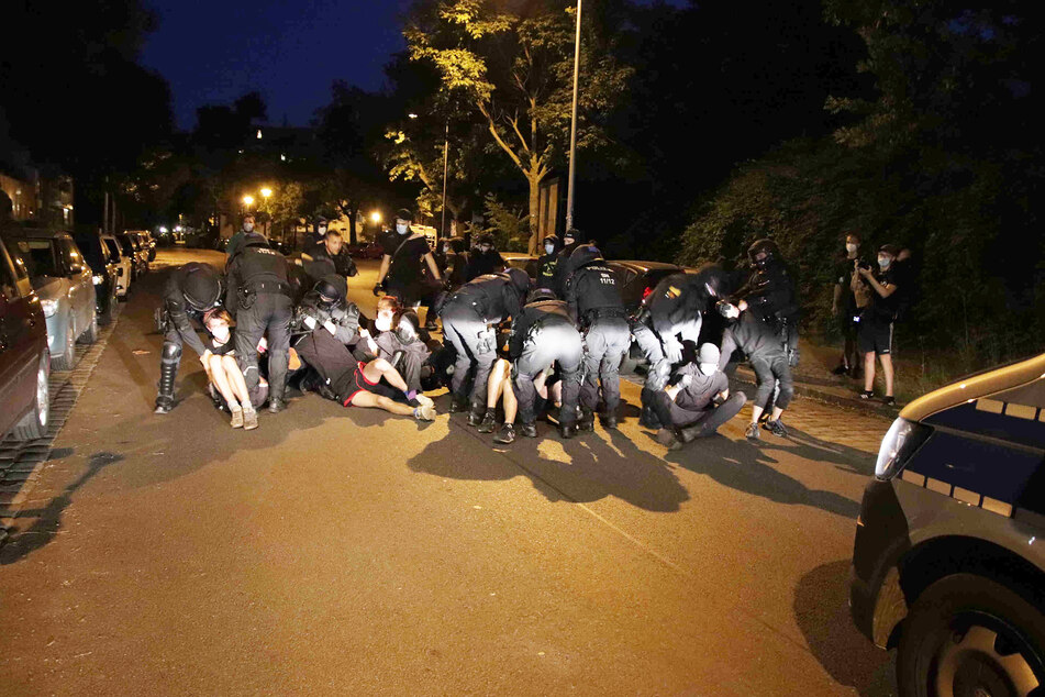 Als die drei Besetzer auf ein Polizeirevier gebracht werden sollten, blockierten rund 50 Personen die Straße. Polizisten mussten sie teils wegtragen.