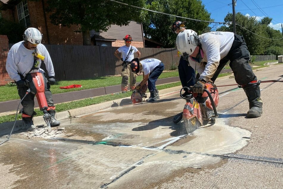 Rescue workers used heavy equipment to hammer and saw the roadway open.