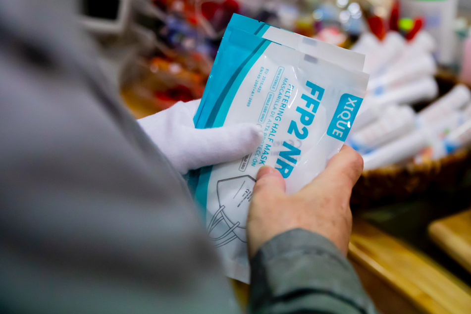 Ein Kunde hält in einer Apotheke FFP2-Masken, welche er im Rahmen der kostenlosen Ausgabe an Risikogruppen erhalten hat.