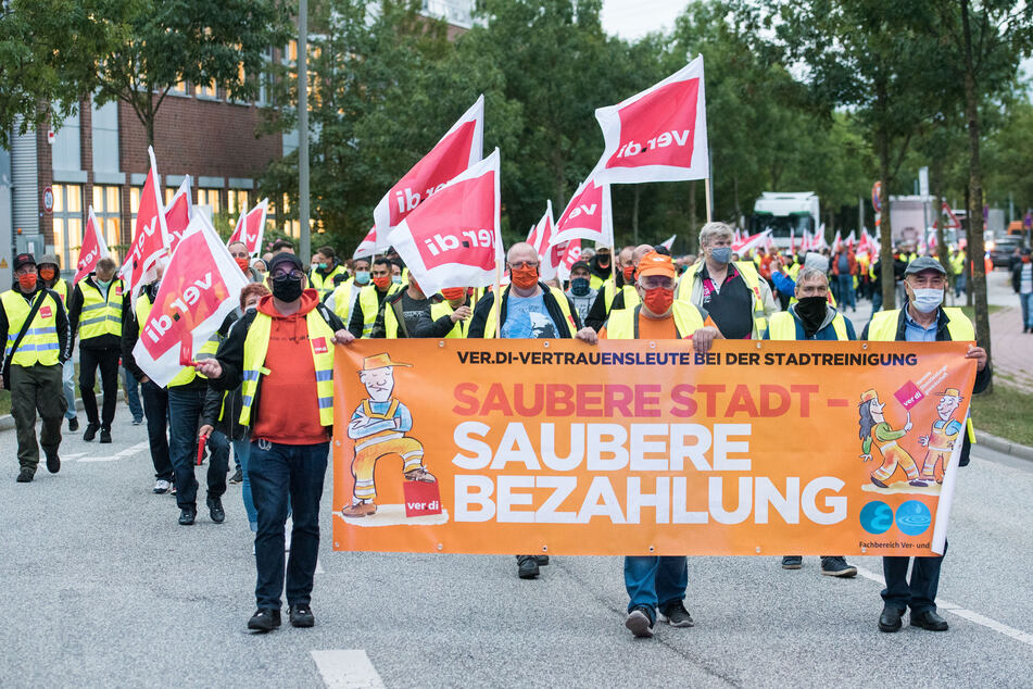 Mitarbeiter der Stadtreinigung ziehen am Morgen durch den Stadtteil Harburg.