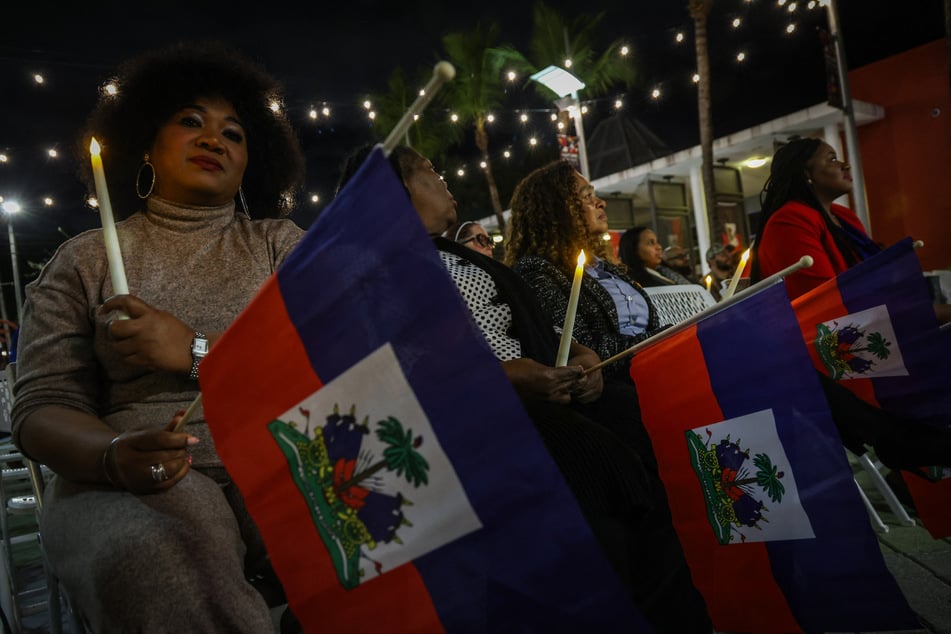 People attend a candlelight vigil for Haitians living in the US under the Temporary Protected Status immigration program in Miami, Florida, on February 3, 2026.
