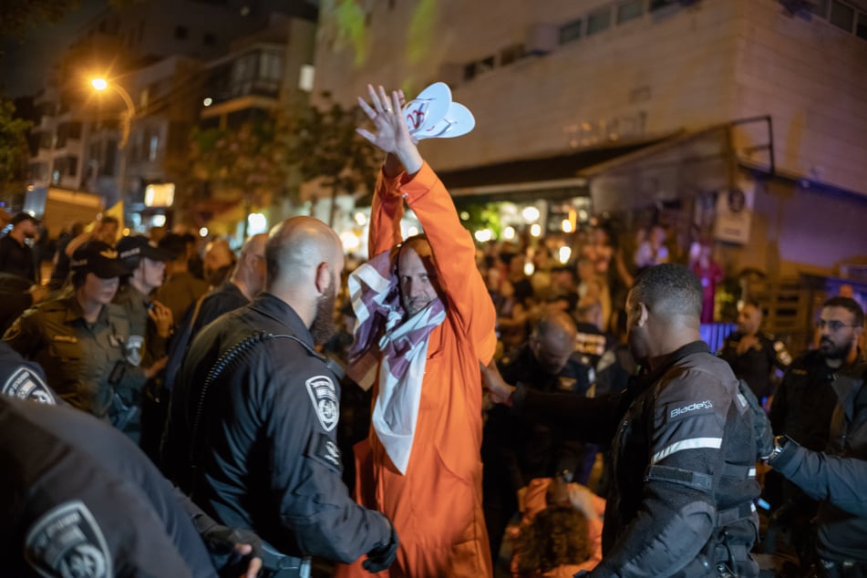 Polizeibeamte nehmen Demonstranten fest während Familien von Geiseln und Unterstützer vor dem Hauptquartier der Likud-Partei bei einer Kundgebung demonstrieren.