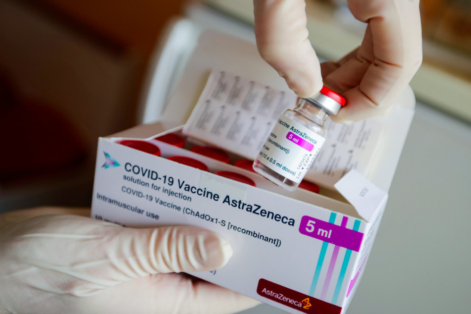 Eine Ampulle des Corona-Impfstoffs von AstraZeneca wird in einer Arztpraxis aus einer Packung entnommen.