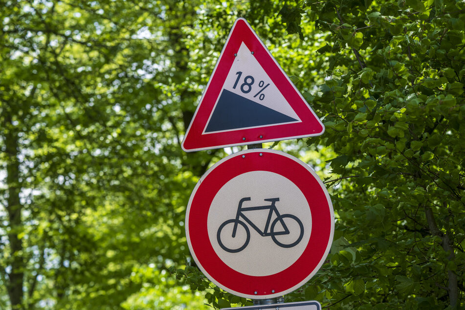 Schilder mit dem Hinweis auf "18 Grad Gefälle" und "Durchfahrt für Radfahrer verboten" stehen nahe der oberbayerischen Gemeinde.