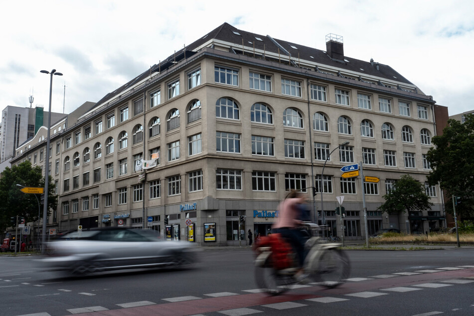 Ein Pkw und eine Radfahrerin fahren an dem Haus vorbei, in dem das links-alternative Jugendzentrum "Potse" in Schöneberg untergebracht ist.