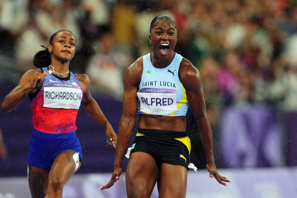 Julien Alfred of St. Lucia (l.) celebrates after crossing the line to win gold ahead of silver medalist Sha'Carri Richardson of Team USA.