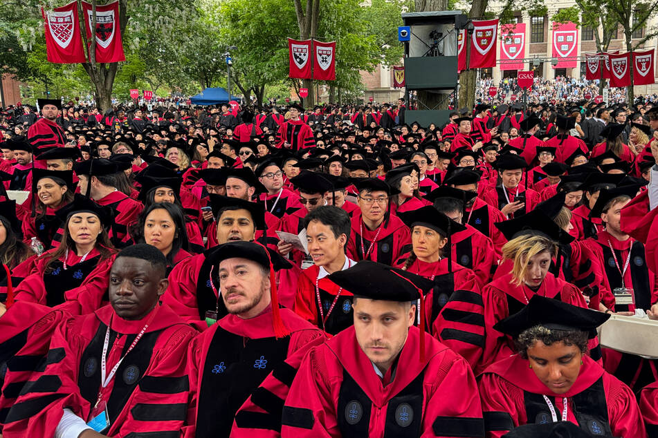 Thousands of Harvard students in crimson-fringed gowns celebrated their graduation Thursday as the university's legal fight against President Trump continues.