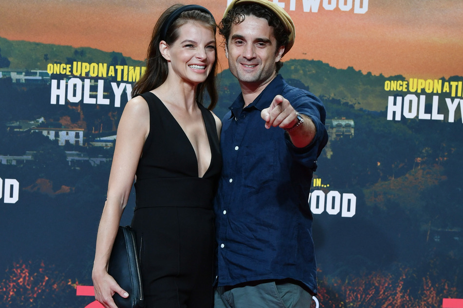 Yvonne Catterfeld strahlt an der Seite ihres Mannes Oliver Wnuk bei einer Filmpremiere im Jahr 2019 (Foto: Jens Kalaene/dpa-Zentralbild/dpa).