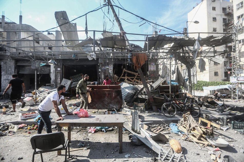 Palästinenser bergen Habseligkeiten aus den zerstörten Gebäuden nach einem israelischen Angriff auf das Karama-Viertel in Gaza-Stadt.