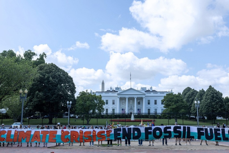 Climate activists chant as they occupy Lafayette Park with a 120-foot banner demanding President Biden act on climate change on July 4, 2023, in Washington DC.