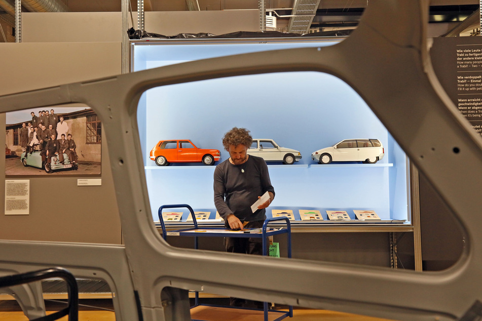 Mitarbeiter Bernhard Stärk platziert Modelle von Trabant-Prototypen, die nie gebaut wurden. Im Vordergrund ein Schnittmodell des Trabant P601.