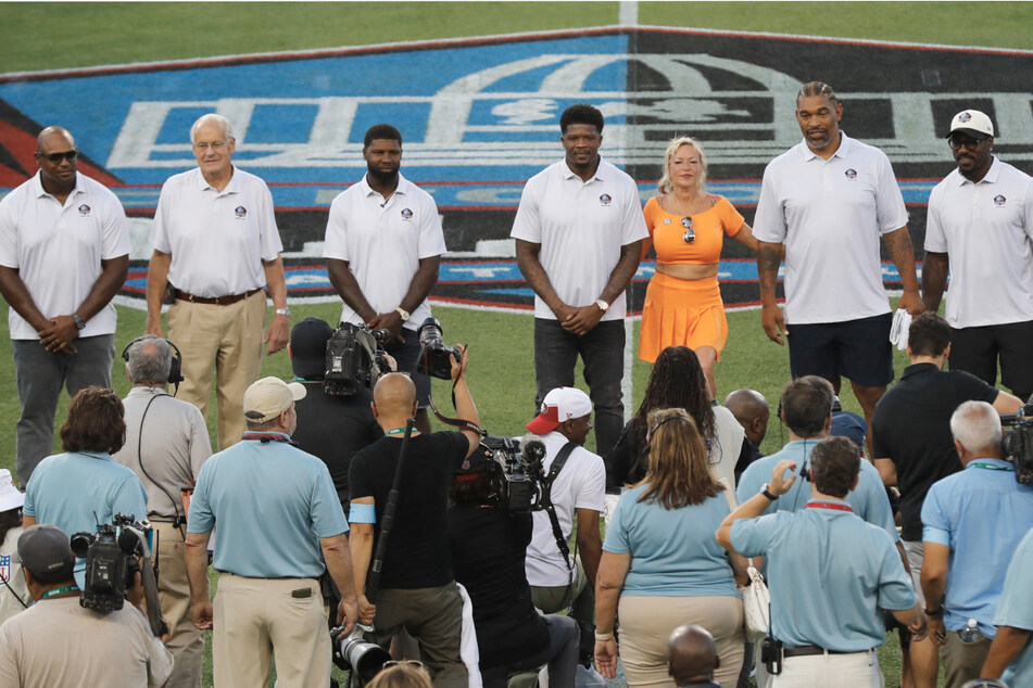 The 2024 Professional Football Hall of Fame induction class (from l. to r.): Dwight Freney, Randy Gradishar, Devin Hester, Andre Johnson, Misty McMichael representing her husband Steve McMichael, Julius Peppers, and Patrick Willis.