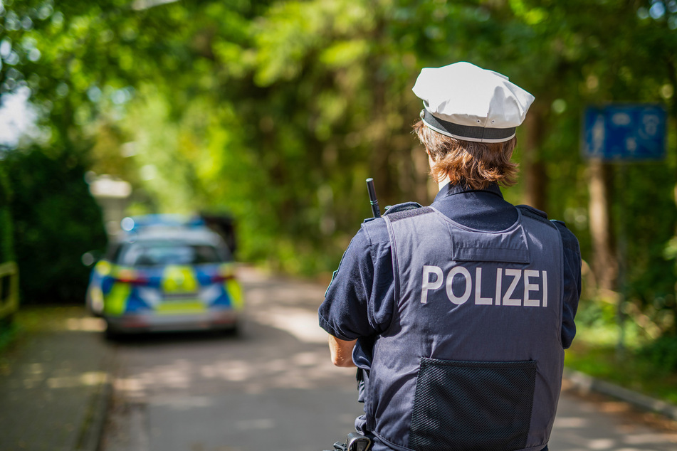 Ein Polizist steht in einer Wohngegend in Schleswig-Holstein. (Symbolfoto)