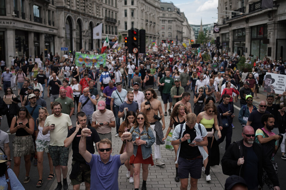 Demonstranten gehen am Samstag bei einem Protest für ein Ende der Maßnahmen zur Eindämmung der Corona-Pandemie und des Lockdowns die Regents Street entlang.