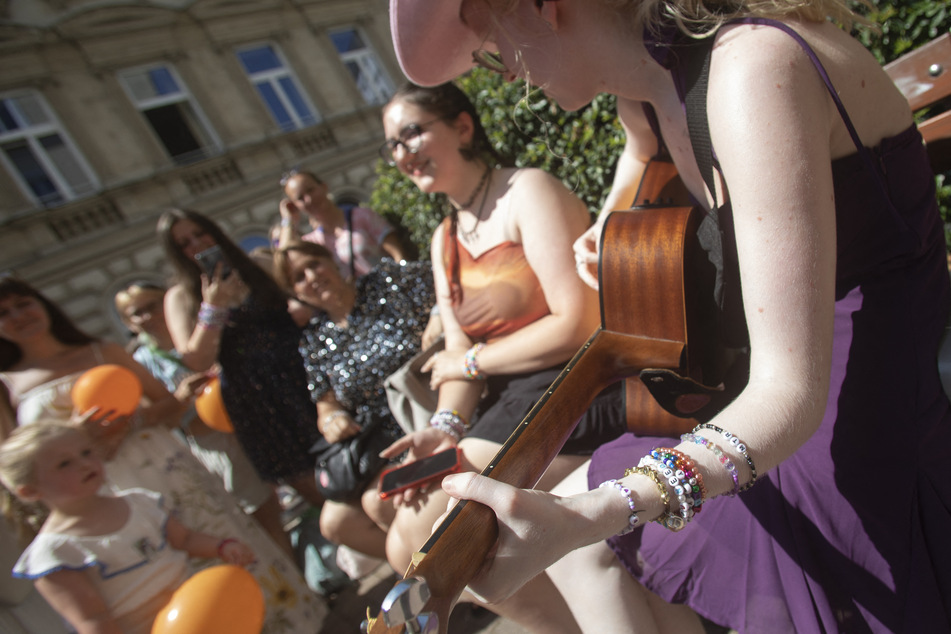 Fans of Taylor Swift stand and sing together on Cornelius Strasse Street in Vienna, Austria on Thursday.