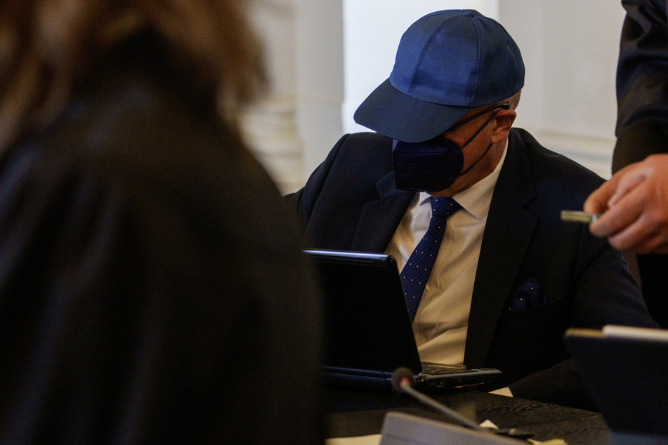 Einer der Angeklagten sitzt auf der Anklagebank im Landgericht in Karlsruhe.