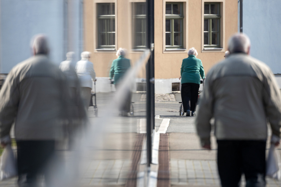 Ältere Menschen machen trotz der Situation um das Coronavirus in der Sonne einen Spaziergang. (Symbolbild)