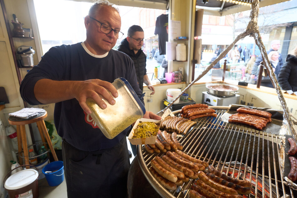 Standbetreiber Herbert Meyer gibt der Dubai-Currywurst den letzten Schliff.