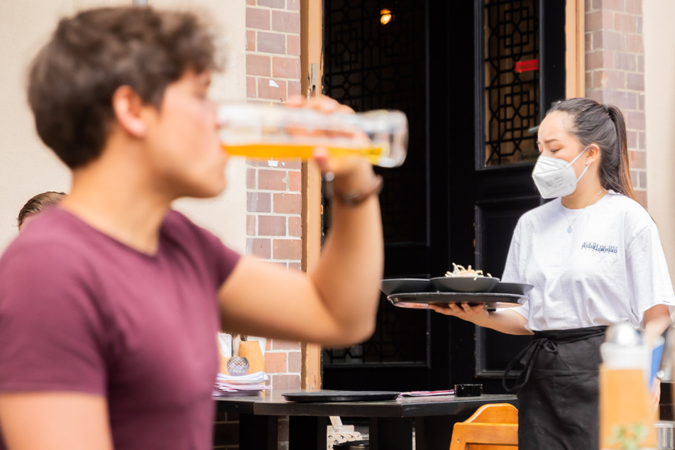 Eine Kellnerin, trägt im Berliner Bezirk Prenzlauer Berg in einem Restaurant für asiatische Fusionsküche ein Tablett.