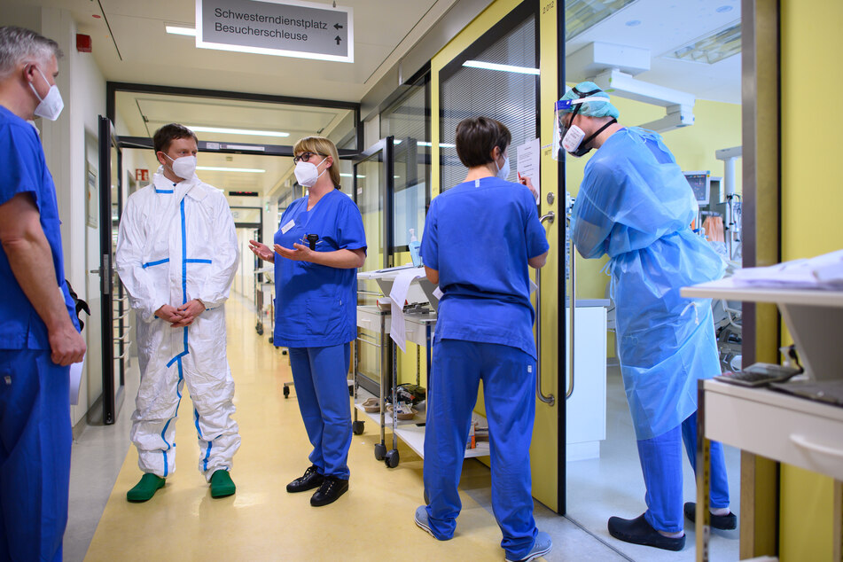 Michael Kretschmer (CDU, 2.v.l.), Ministerpräsident von Sachsen, steht im Vollschutzanzug auf der Covid-19 Intensivstation im Städtischen Klinikum Dresden.