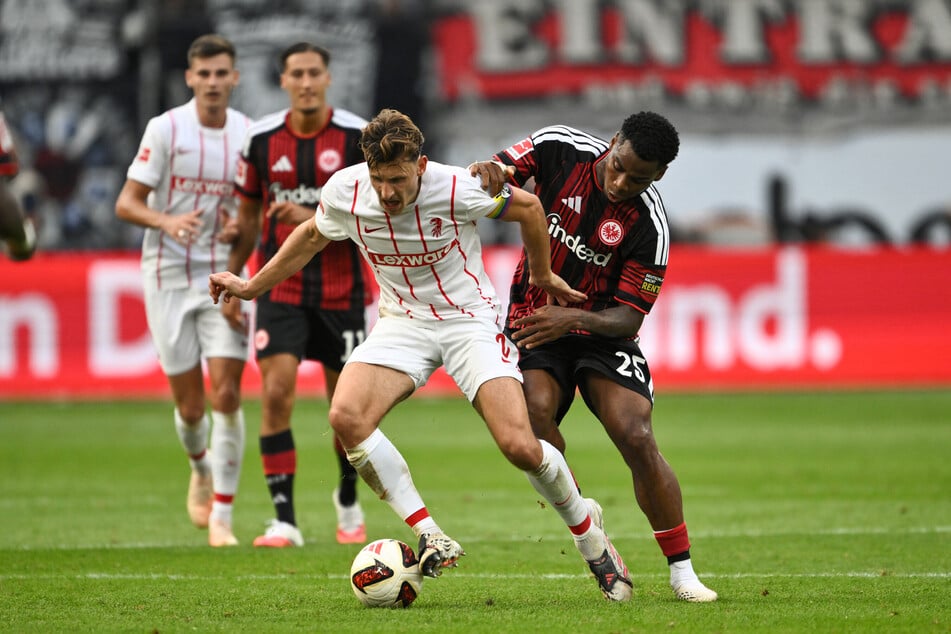 Maximilian Eggestein (SC Freiburg) (l) und Raphael Onyedika (Eintracht Frankfurt) kämpfen um den Ball.