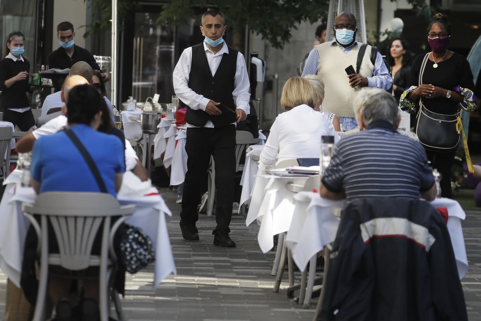 don: Menschen essen in einem Restaurant. Angesichts eines rapiden Anstiegs von Corona-Fällen steht Großbritannien laut Gesundheitsminister Hancock an einem "Wendepunkt".